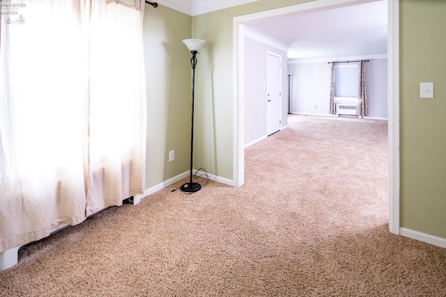 spare room featuring carpet flooring and baseboards