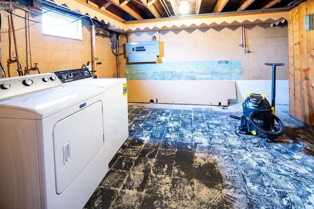 washroom featuring concrete block wall, laundry area, and independent washer and dryer