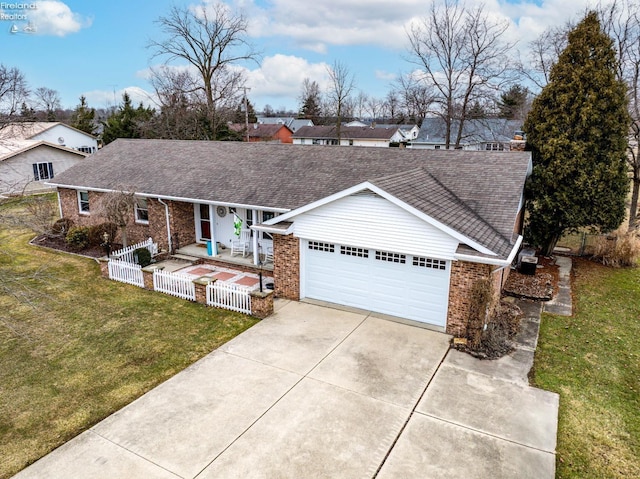 ranch-style house with driveway, fence, a front lawn, and brick siding