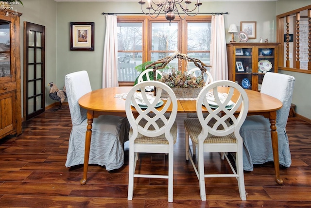 dining area featuring an inviting chandelier, baseboards, and wood finished floors