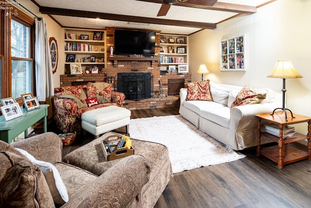 living room with beamed ceiling, a textured ceiling, and wood finished floors