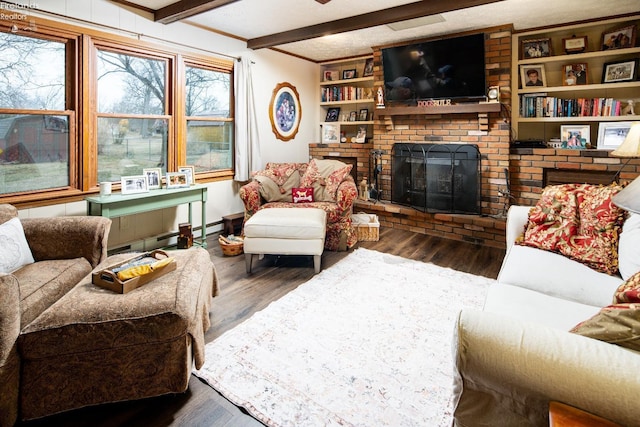 living room with built in shelves, a brick fireplace, beam ceiling, and wood finished floors