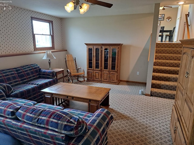 carpeted living area featuring stairs, ceiling fan, and baseboards