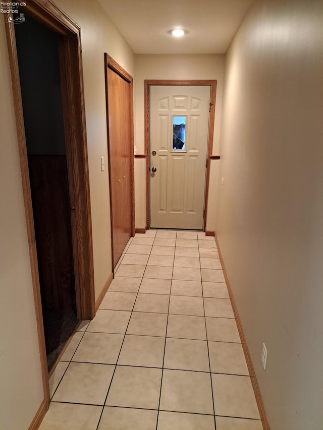 hallway with baseboards and light tile patterned floors