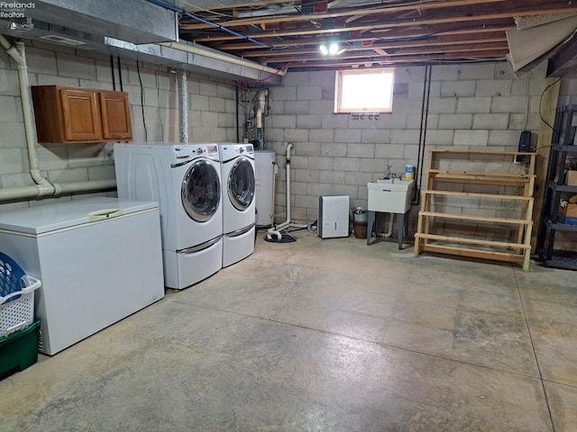 basement featuring fridge, washer and clothes dryer, and a sink