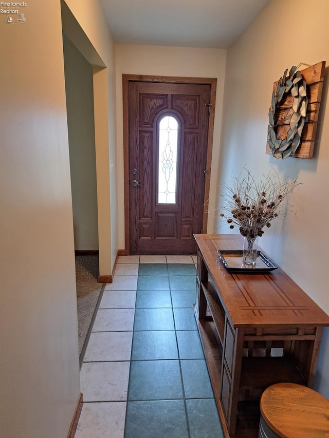 entryway with baseboards and light tile patterned flooring