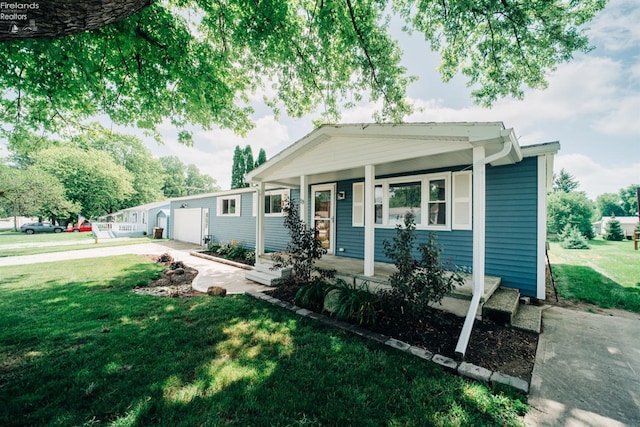 view of front of home featuring a porch, an attached garage, driveway, and a front yard