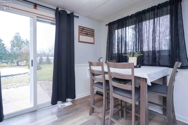 dining area featuring wood finished floors, visible vents, and a wealth of natural light