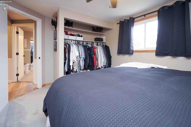 bedroom with wood finished floors, a closet, and ceiling fan