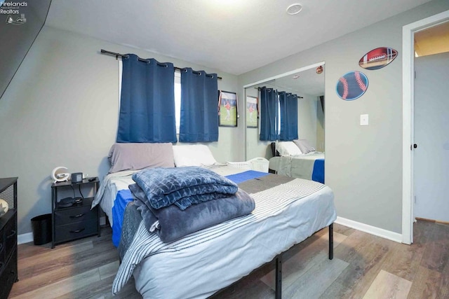 bedroom featuring wood finished floors and baseboards