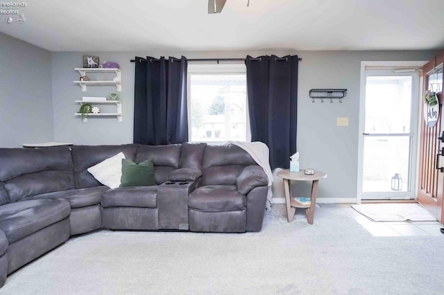 living area featuring a ceiling fan, baseboards, and carpet floors