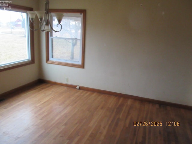 unfurnished dining area featuring baseboards and wood finished floors