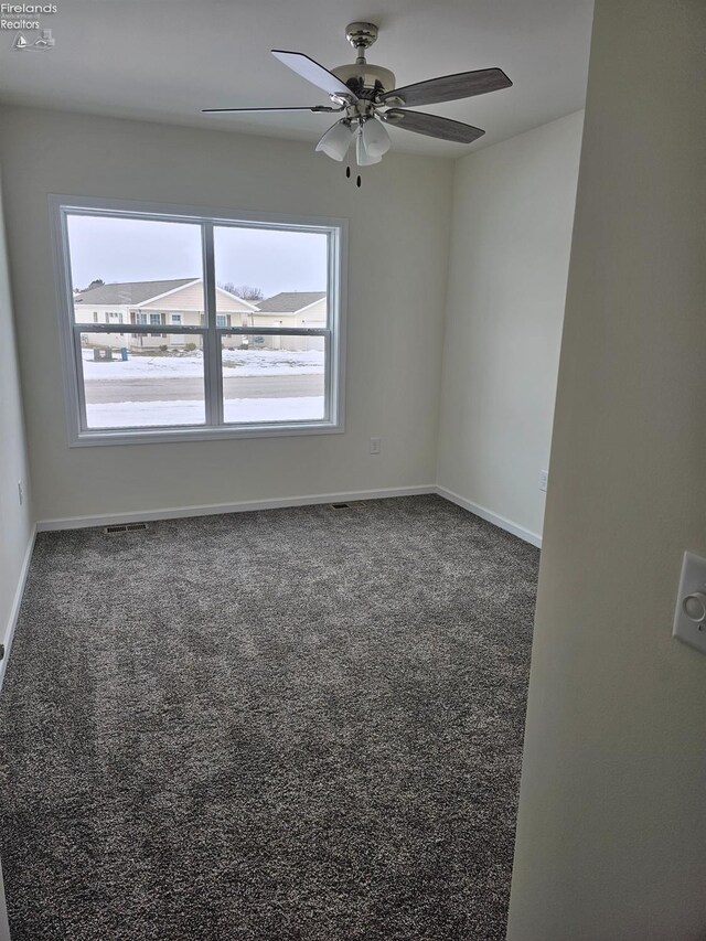 carpeted empty room featuring ceiling fan and baseboards