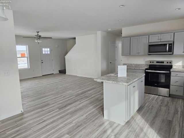 kitchen with light wood-style floors, stainless steel appliances, and gray cabinetry