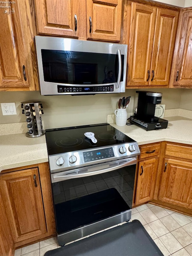 kitchen with appliances with stainless steel finishes, light countertops, and brown cabinetry