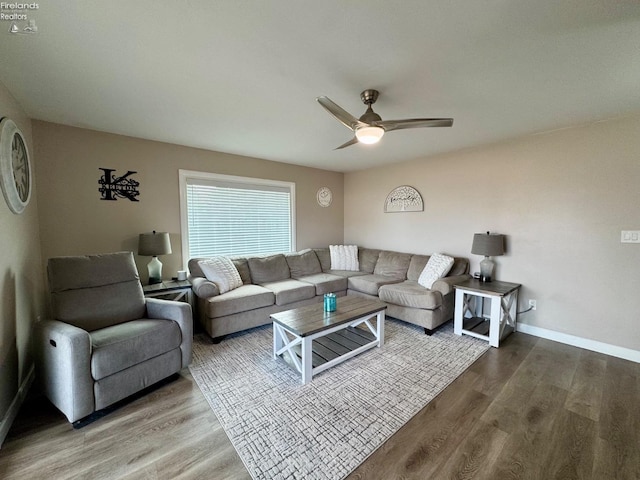 living room featuring wood finished floors, a ceiling fan, and baseboards