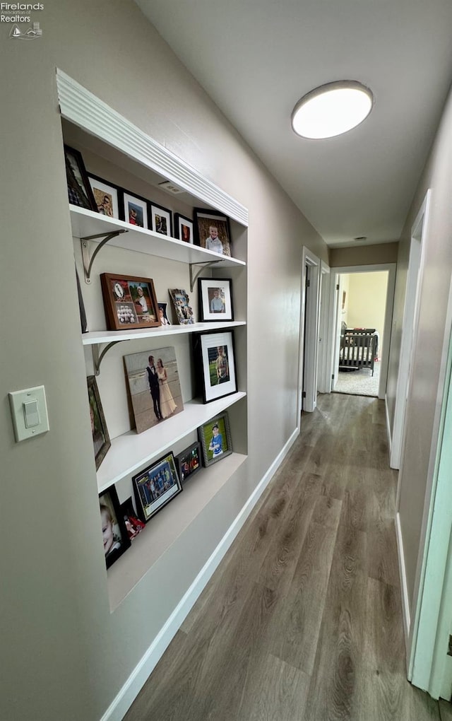 hall with wood finished floors and baseboards