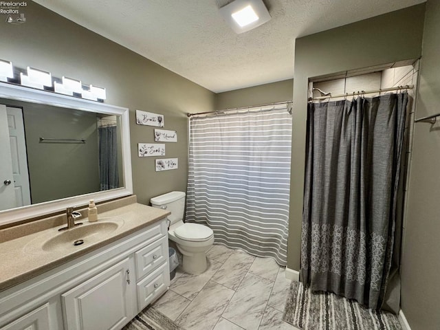 bathroom with marble finish floor, curtained shower, toilet, a textured ceiling, and vanity