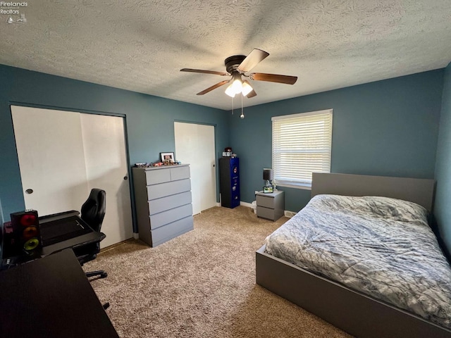 carpeted bedroom featuring a ceiling fan, a textured ceiling, and baseboards