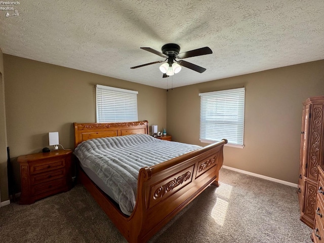 carpeted bedroom with a textured ceiling, baseboards, and a ceiling fan