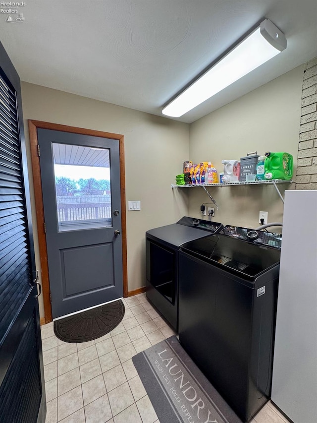 laundry area featuring washer and dryer, laundry area, and light tile patterned flooring