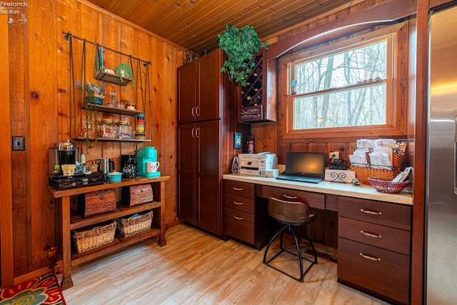 office area featuring wood ceiling, built in desk, light wood-style flooring, and wooden walls