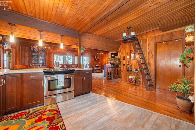 kitchen featuring light countertops, electric range, wood walls, and light wood-style flooring