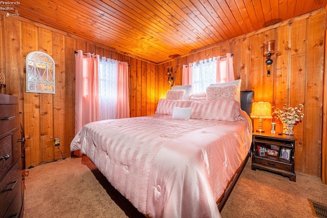 bedroom with wooden ceiling, carpet flooring, wood walls, and visible vents