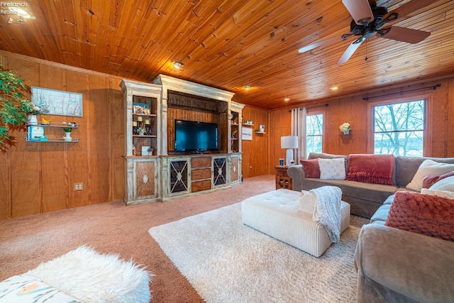 living room featuring ceiling fan, carpet floors, wood ceiling, and wooden walls