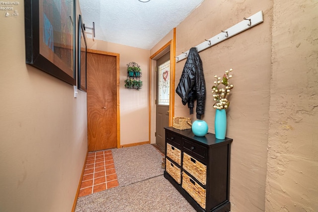 entryway featuring a textured ceiling, tile patterned floors, and baseboards