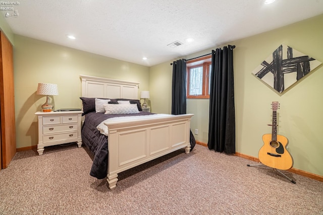 bedroom with a textured ceiling, carpet, visible vents, and baseboards