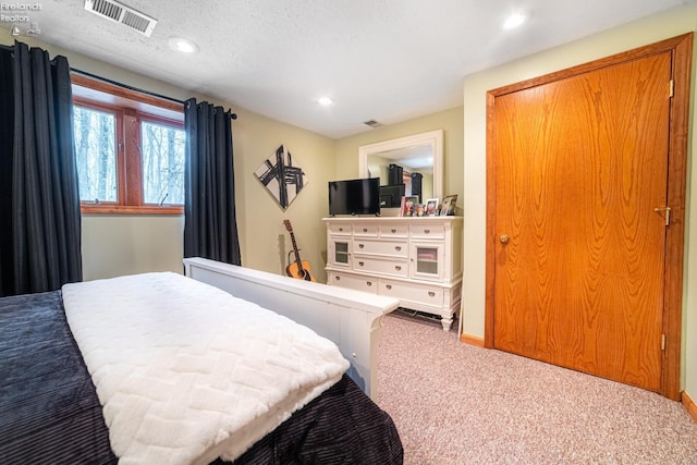 carpeted bedroom with baseboards, visible vents, a textured ceiling, and recessed lighting