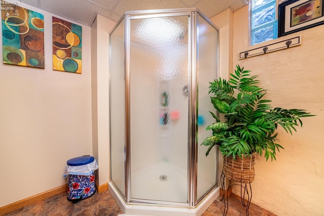 bathroom with a shower stall and baseboards