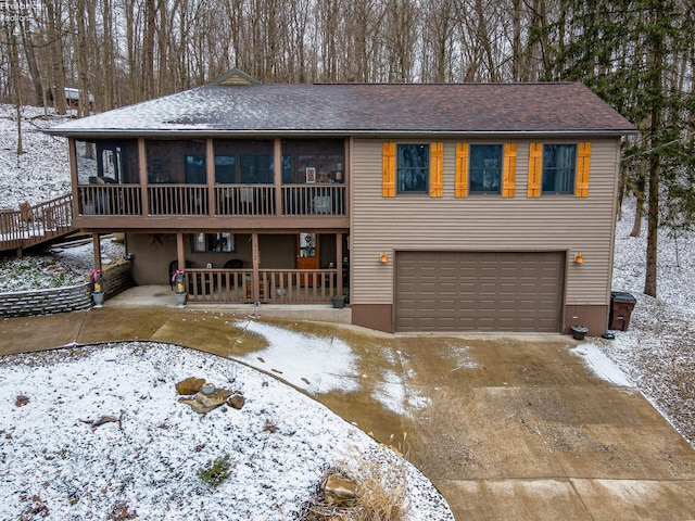 view of front facade with a garage, a sunroom, and concrete driveway