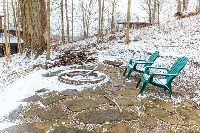 yard layered in snow with an outdoor fire pit