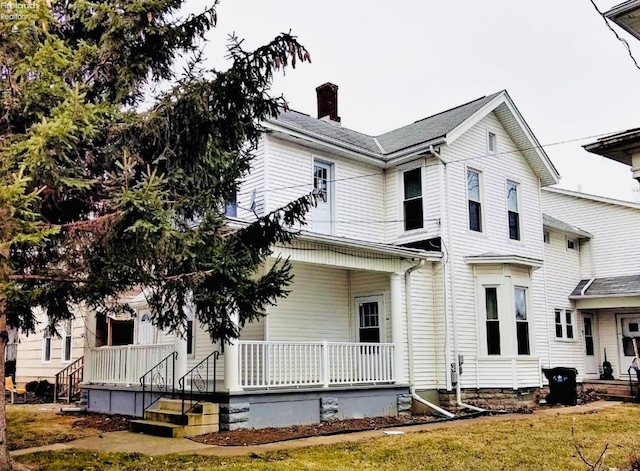 view of front of house with a chimney and a porch