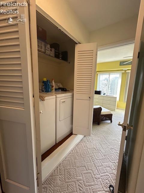 clothes washing area featuring light carpet, laundry area, and independent washer and dryer