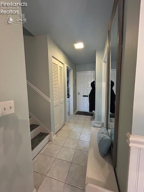 hall featuring stairway and light tile patterned floors