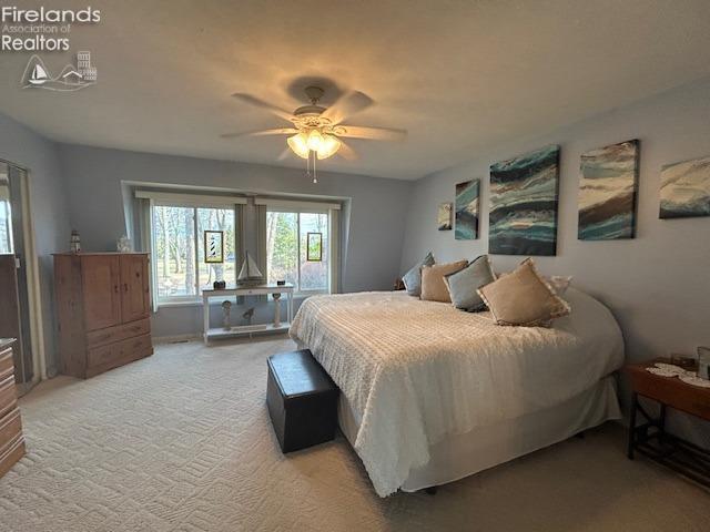 bedroom featuring light carpet and ceiling fan