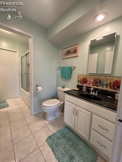 full bathroom featuring bath / shower combo with glass door, vanity, toilet, and tile patterned floors