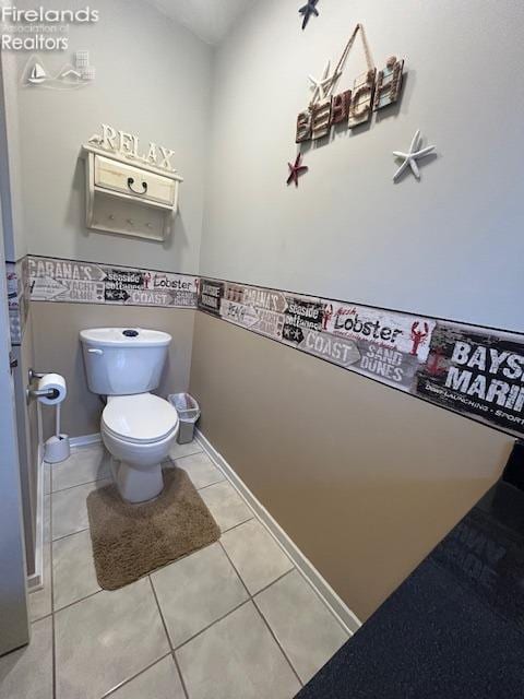 bathroom with toilet, baseboards, and tile patterned floors