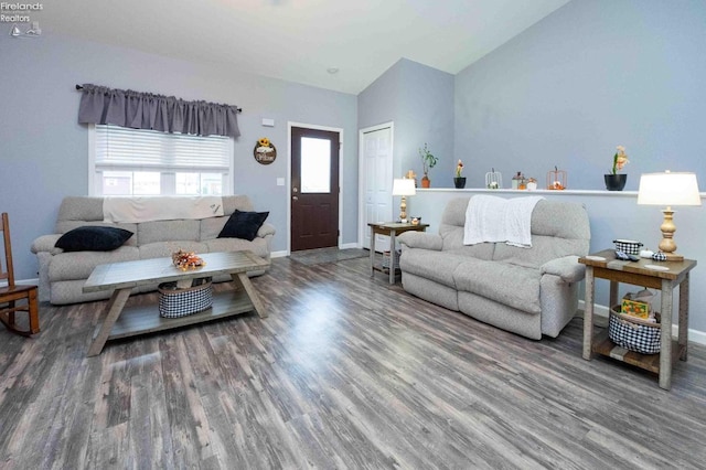 living room featuring baseboards, vaulted ceiling, and wood finished floors