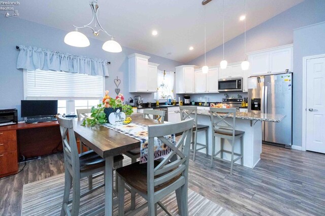 dining area featuring high vaulted ceiling, wood finished floors, and recessed lighting