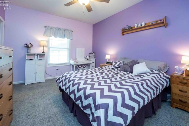 carpeted bedroom with ceiling fan and baseboards