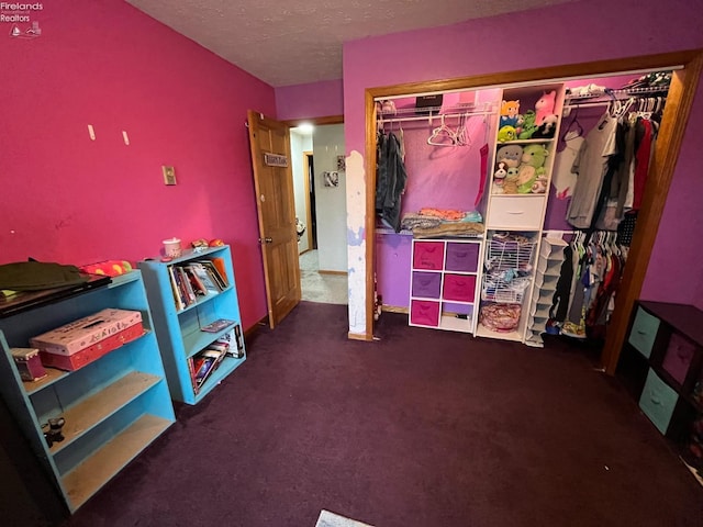 interior space featuring a textured ceiling, carpet floors, and a closet