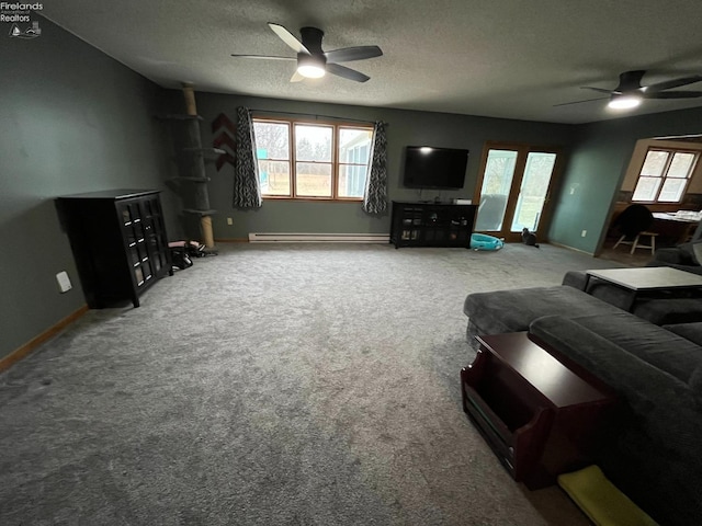 living room featuring carpet, plenty of natural light, a ceiling fan, and a textured ceiling