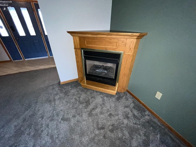 interior details with carpet floors, baseboards, and a glass covered fireplace