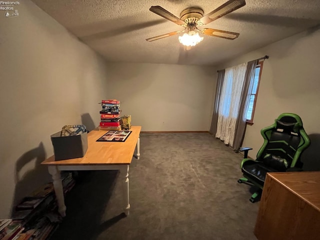 carpeted home office featuring baseboards, a ceiling fan, and a textured ceiling