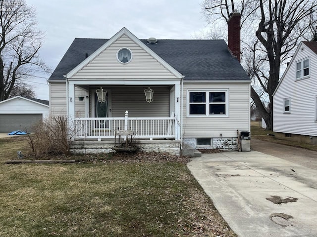 view of front of house with roof with shingles, a chimney, a porch, and an outdoor structure