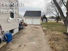 view of property exterior with a garage, driveway, and an outbuilding